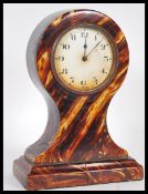 A late 19th / early 20th Century tortoiseshell balloon clock having a white enamel face with bold