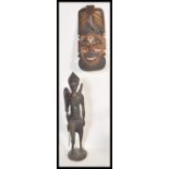 Two 20th Century African carved wooden artifacts to include a large ebony warrior fertility statue