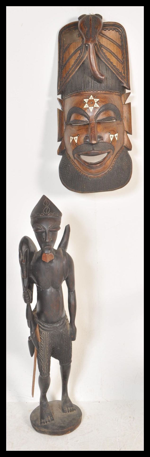 Two 20th Century African carved wooden artifacts to include a large ebony warrior fertility statue