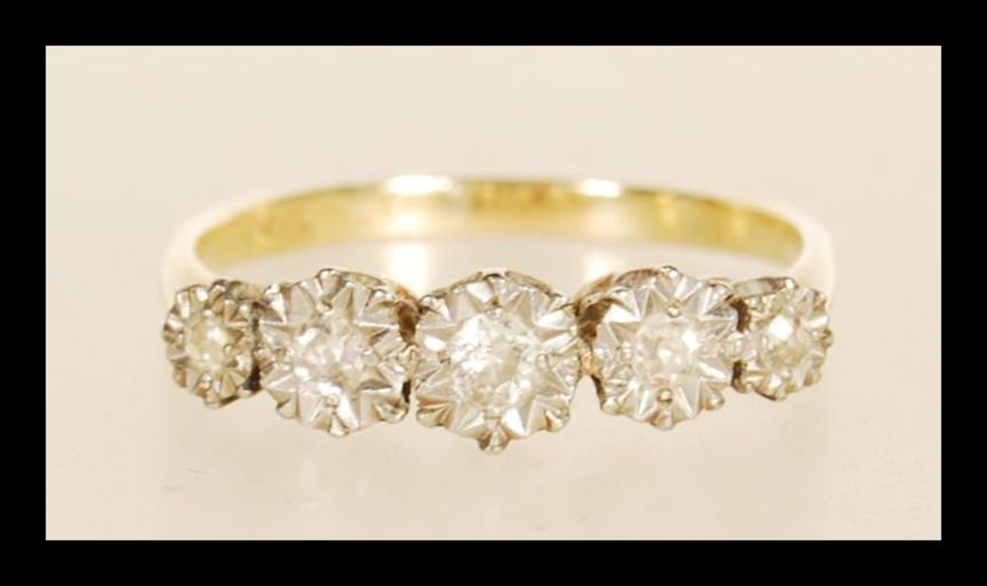 A stamped 18ct gold ring illusion set with five old cut diamonds. Weight 2.5g. Size O.