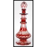 A 19th Century Bohemian faceted cut red glass bottle raised on fluted circular foot with bulbous