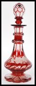 A 19th Century Bohemian faceted cut red glass bottle raised on fluted circular foot with bulbous