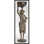 A 20th Century African fertility bronze figure, the figure raised on a circular base of a mother