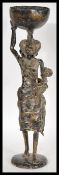 A 20th Century African fertility bronze figure, the figure raised on a circular base of a mother