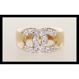 A 9ct gold 9k stamped designer ring in the manner of Channel having white stone set cross C design