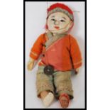 A vintage early 20th Century Chinese papier-mâché and silk doll, the papier-mâché head with