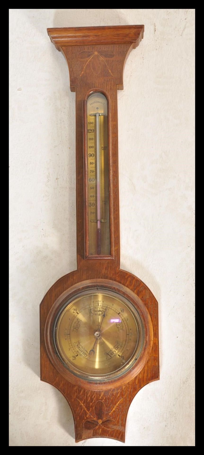 An early 20th Century Edwardian oak cased banjo wall barometer having inlaid swag ribbon