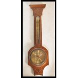 An early 20th Century Edwardian oak cased banjo wall barometer having inlaid swag ribbon