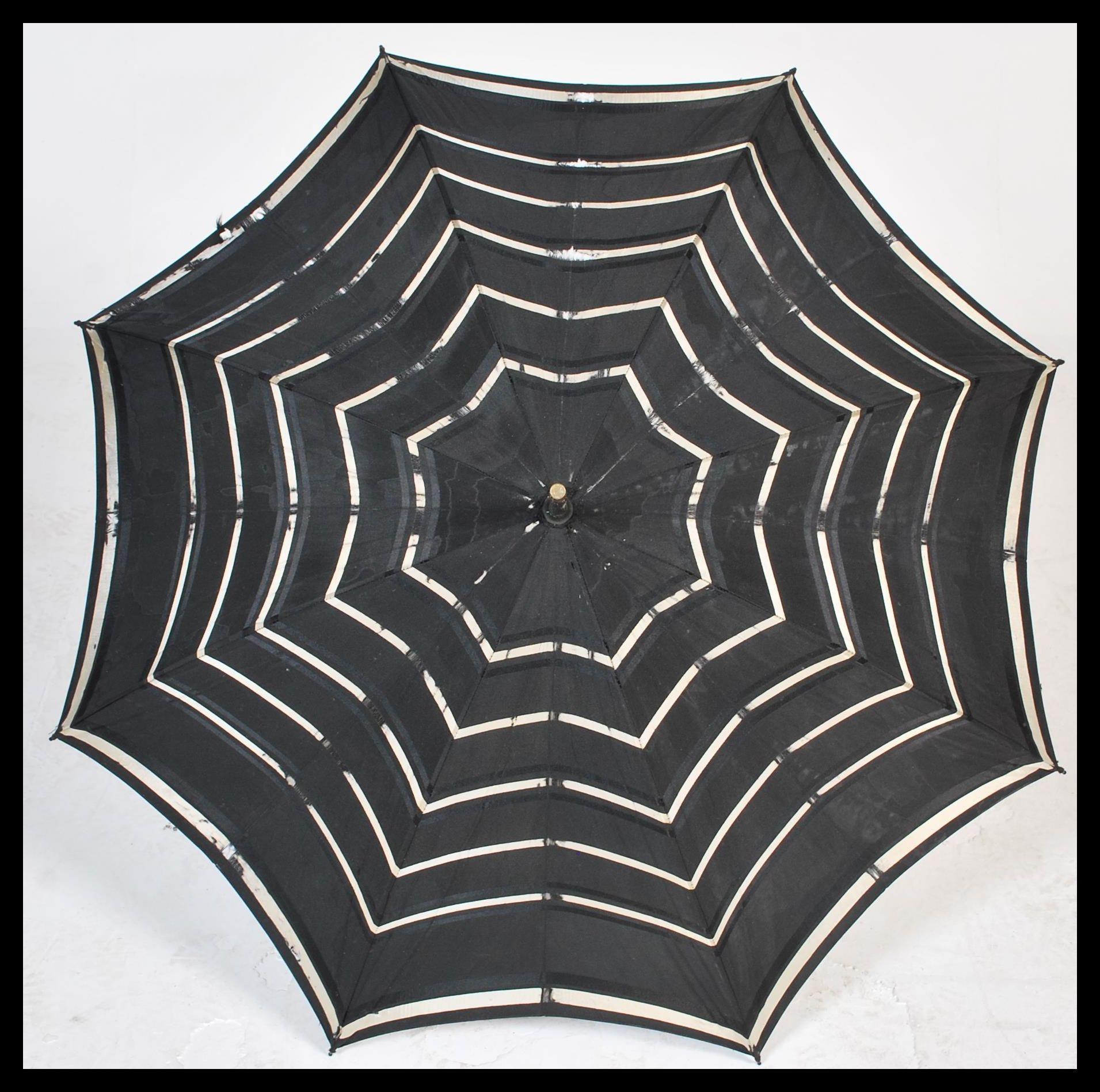 An early 20th Century Edwardian silk parasol with an ebonised carved handle the silk with