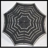 An early 20th Century Edwardian silk parasol with an ebonised carved handle the silk with