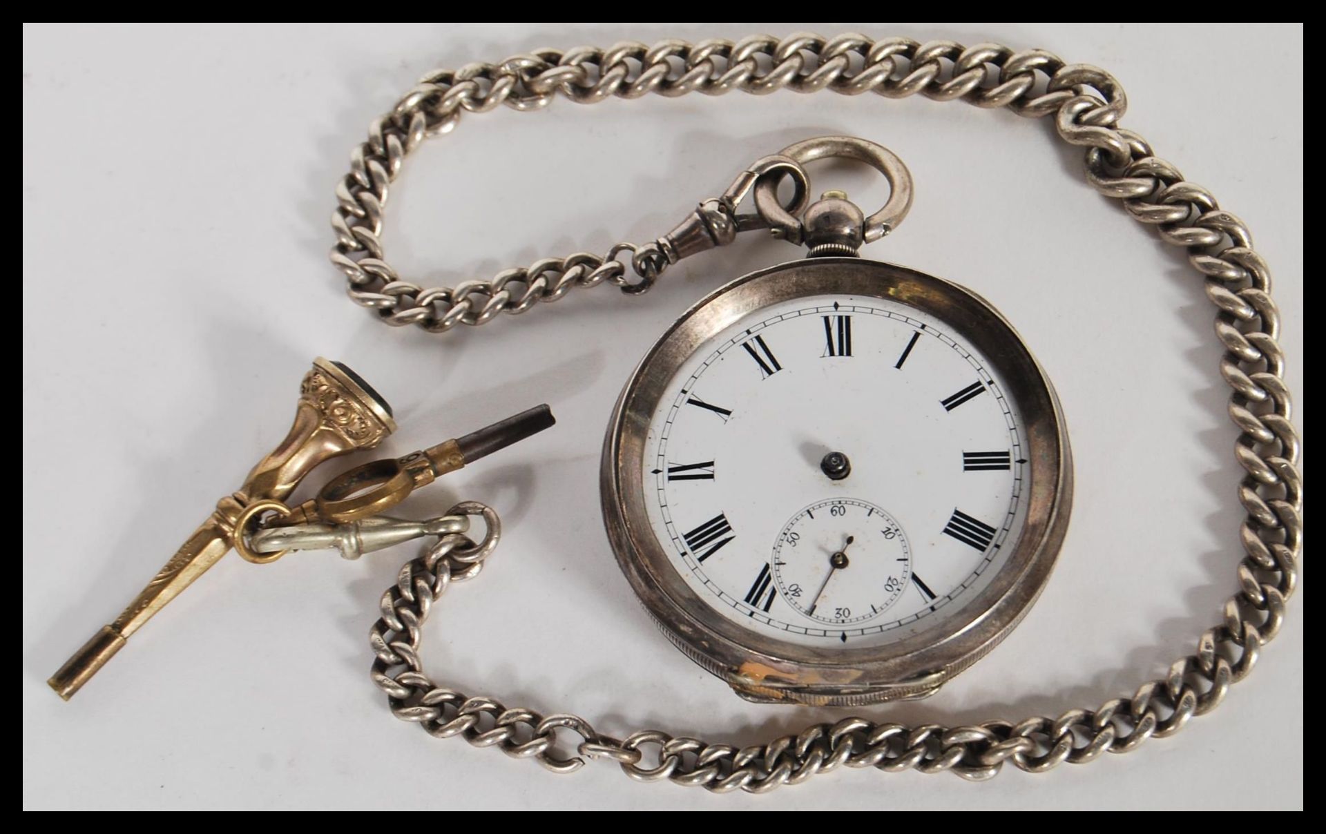 A 19th Century Victorian hallmarked silver pocket watch complete with silver albert chain and yellow