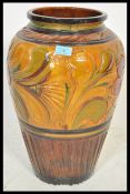 A large early 20th Century Art Nouveau pottery vase / stick stand of bulbous form having hand