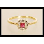 A stamped 18ct gold ring having a round platinum head set with a square cut ruby surrounded by