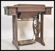 A 19th Century Victorian Singer sewing machine raised on oak treadle table supports.