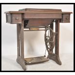 A 19th Century Victorian Singer sewing machine raised on oak treadle table supports.