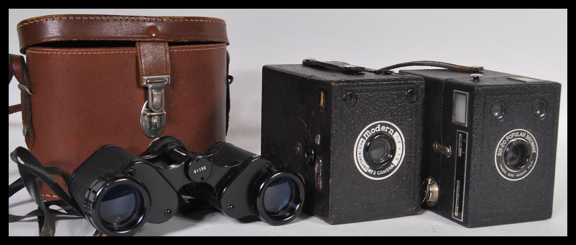 A pair of Hartzmann Wetzler 117 binoculars set within a brown leather case along with two box film