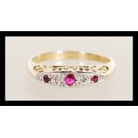 An 18ct gold stamped diamond and garnet stone ring having flush stone setting with scroll