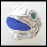 A stamped 925 silver pin cushion in the form of a toad having a blue fabric cushion to the mouth,