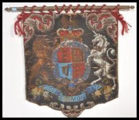 A 19th Century Victorian hand embroidered bead work armorial heraldic crest flag on brass flag pole.