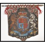 A 19th Century Victorian hand embroidered bead work armorial heraldic crest flag on brass flag pole.