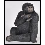 A 20th Century resin figurine in the form of a sitting gorilla, bearing the makers mark Carn to