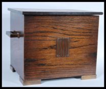 An early 1920's Art Deco oak coal scuttle, bronzed handles to the side with applied bronzed panel