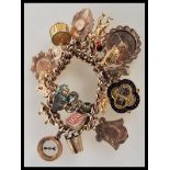 An early 20th Century stamped 9ct gold charm bracelet with a heart lock fastening, having a total of