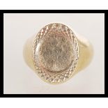 A hallmarked 9ct gold signet ring with engine turned decoration, weight 9.9g. Size T.