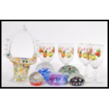 A collection of glass paperweights including two millefiori design and a murano glass basket,