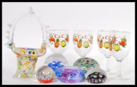 A collection of glass paperweights including two millefiori design and a murano glass basket,