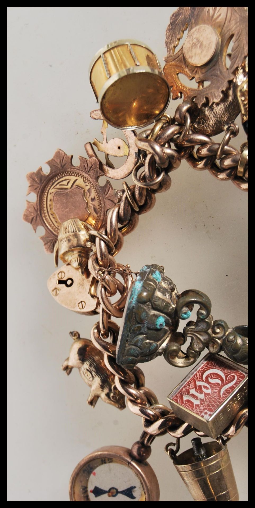 An early 20th Century stamped 9ct gold charm bracelet with a heart lock fastening, having a total of - Bild 5 aus 5