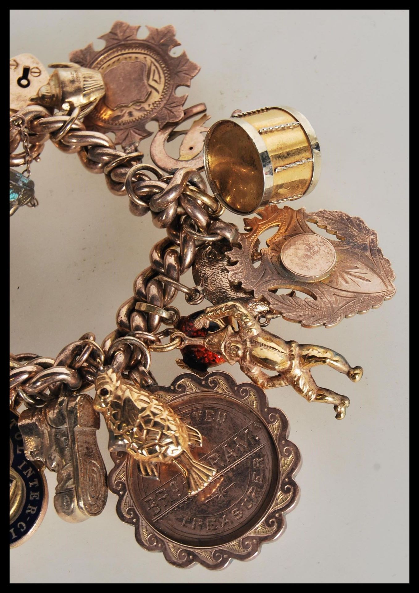 An early 20th Century stamped 9ct gold charm bracelet with a heart lock fastening, having a total of - Bild 4 aus 5