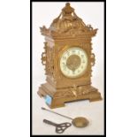 A 19th Century Victorian gilt brass mantel clock raised on a bracket base with armorial decoration
