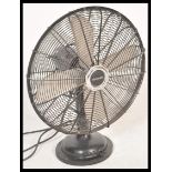 A vintage retro 20th Century industrial desk top fan by Micromark having a wire cage with steel