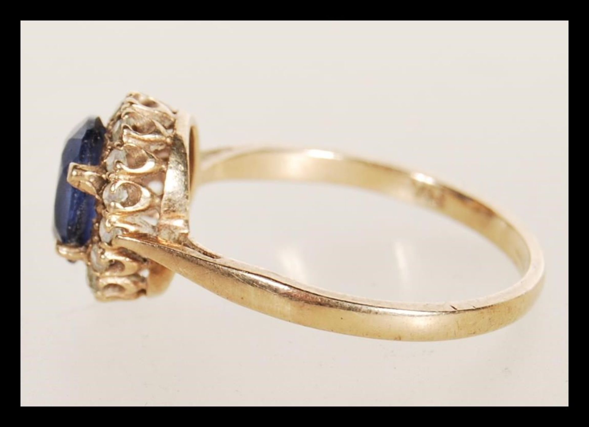 A hallmarked 9ct gold ring prong set with an oval cut synthetic sapphire set with a halo of white - Bild 2 aus 4