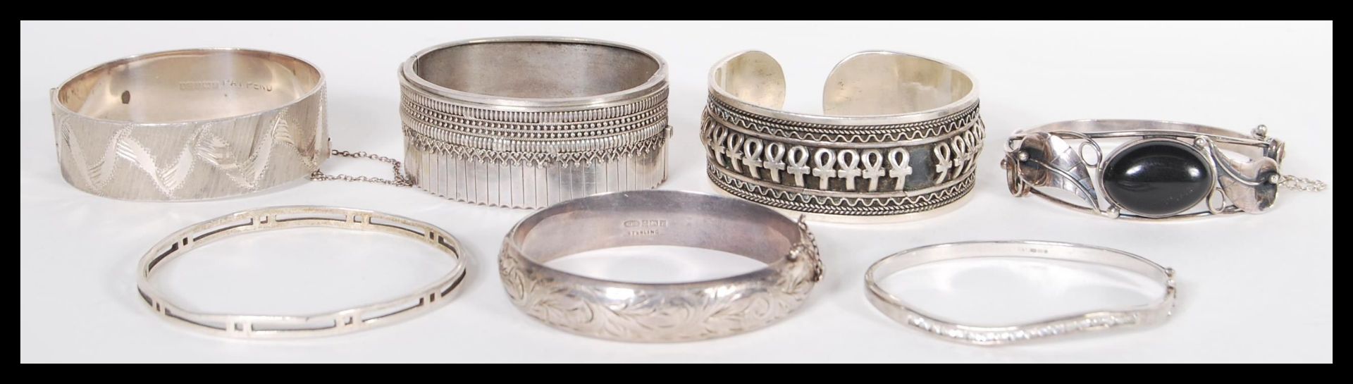 A group of seven silver hallmarked and sterling silver bangle bracelets two include a large