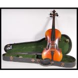 A vintage 20th Century violin musical instrument having a two piece maple back with spruce front.