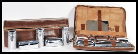 Two vintage 20th Century Gentleman's travelling cased vanity sets having glass bottles and pots with