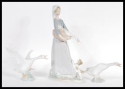 A Lladro ceramic figurine group depicting a girl with goose model 4866 along with two Lladro geese