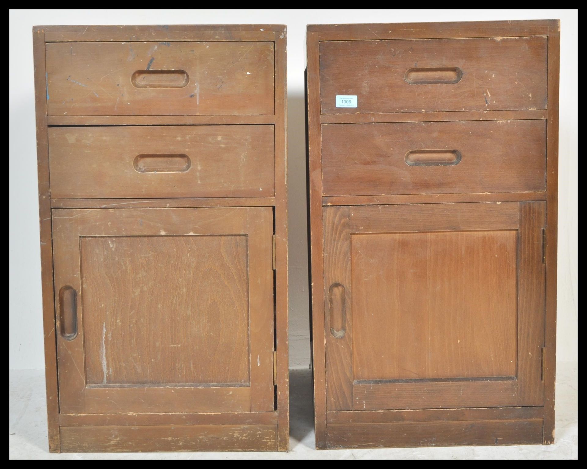 A pair of vintage 20th Century military bedside locker cabinets having a configuration of two