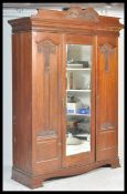 A 19th Century Art Nouveau  triple mahogany compactum wardrobe, central mirrored door flanked by