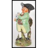 A early 19th Century Staffordshire Toby fillpot jug, the gentleman being dressed in a light green