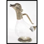 An early 20th Century silver plated and glass novelty claret jug in the form of a duck raised on a