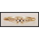 A vintage 9ct gold bangle bracelet of circular form having a flush row of black and white stones