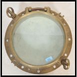 A vintage 20th Century large brass framed nautical ships window porthole having inset glass panel