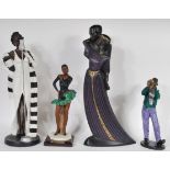 A collection of tall Art Deco style composite figurines to include an embracing couple, a jazz