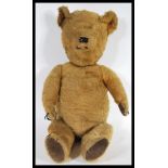 A vintage mid 20th Century childs teddy bear constructed from mohair with leather patches to the