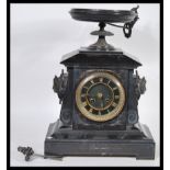 A late 19th century black slate cased mantel clock, of architectural form, the whole surmounted by