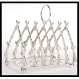 A silver plated toast rack of hunting interest with the rack being in the form of crossed rifles.