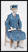 A Lladro ceramic figurine entitled the Graduate model 5198 in the form of a male student in